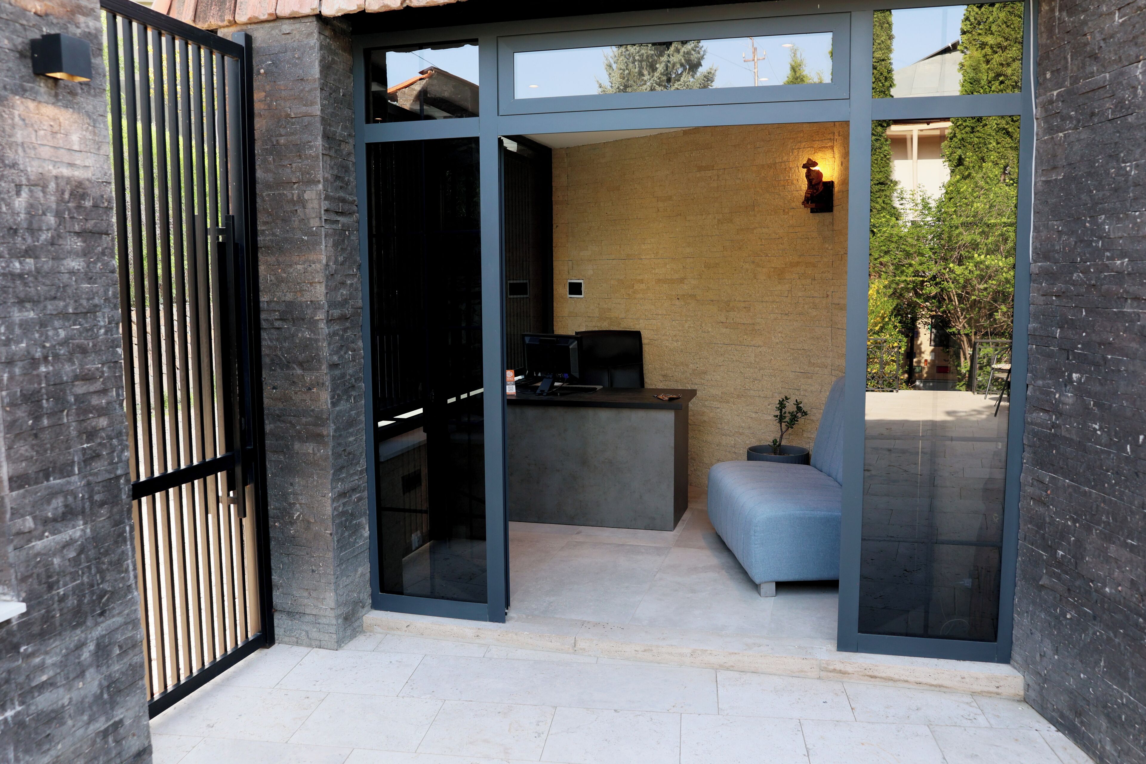 A modern interior with a glass door leading to a seating area, a small table, and a television.