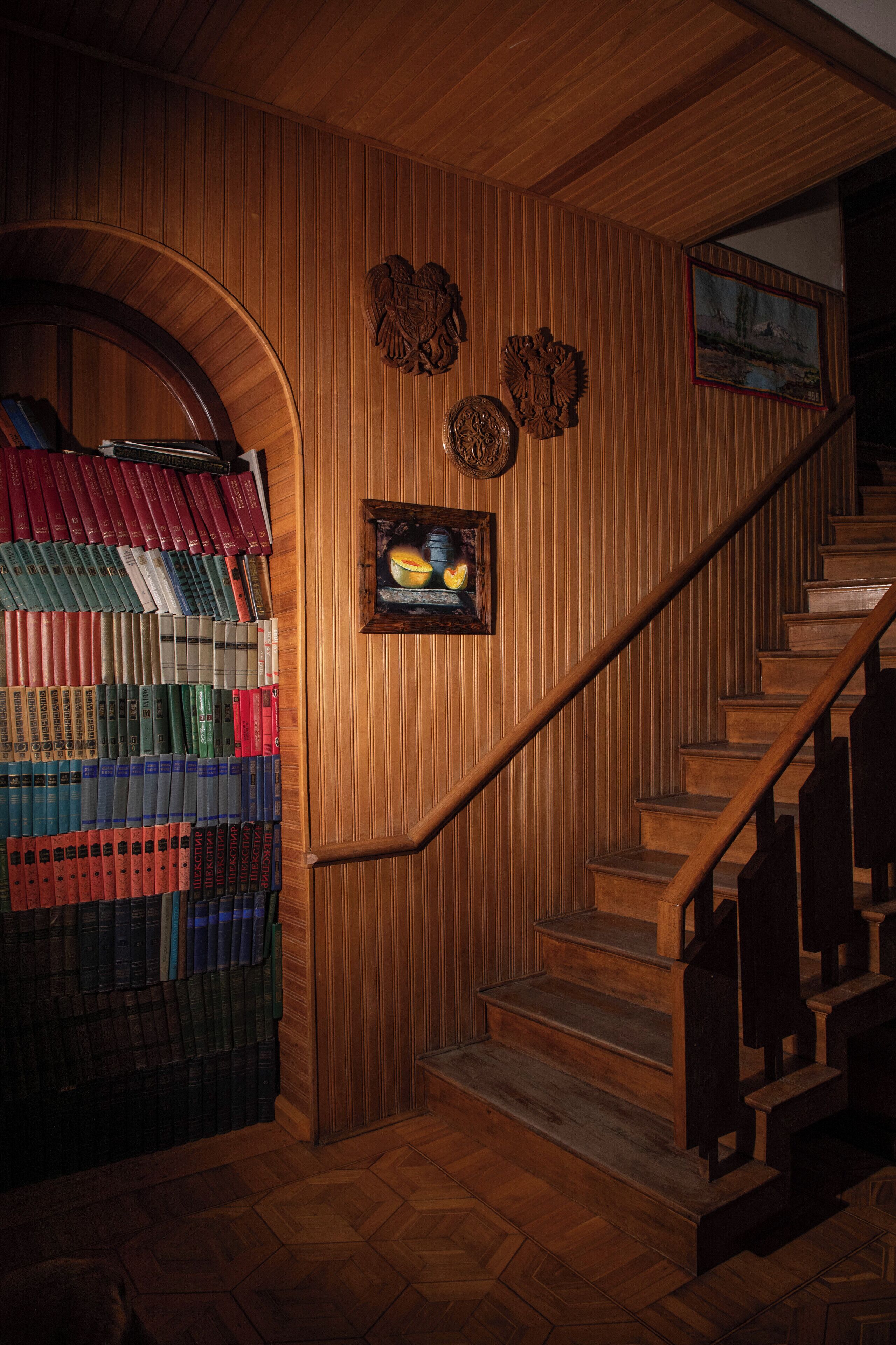A wooden staircase with a wooden bookcase filled with books.