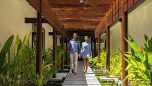 A covered walkway with a wooden ceiling, surrounded by potted plants and a small water feature. - OBLU NATURE Helengeli - All-Inclusive with Free Transfers (Helengeli)