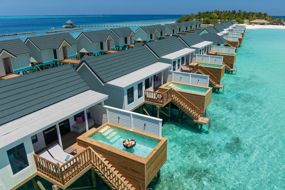 Bungalows sur pilotis dotés de piscines privées, de passerelles en bois et offrant une vue sur l’océan.