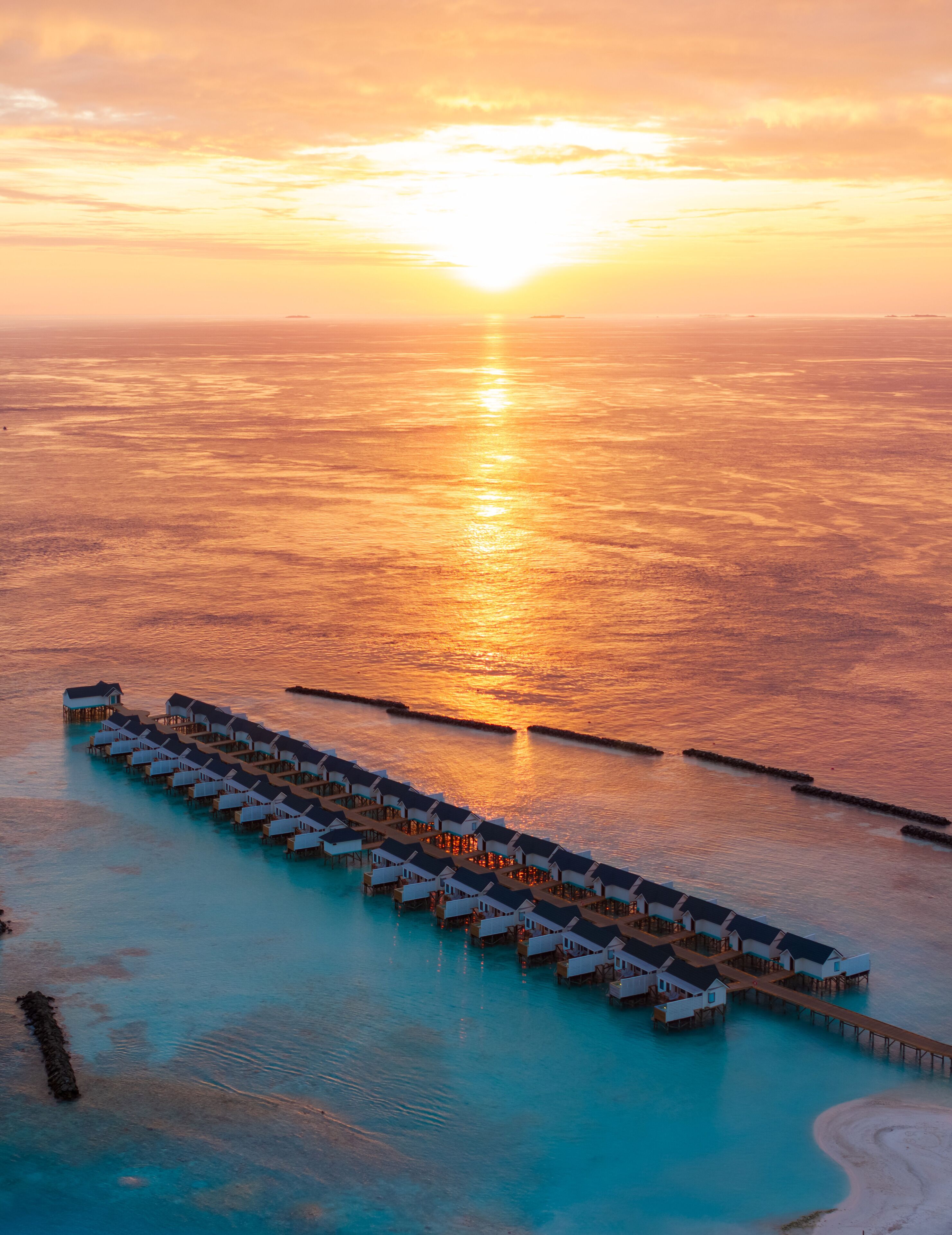 Ein überwasser-Resort mit mehreren Bungalow-Unterkünften, die durch Laufwege verbunden sind.