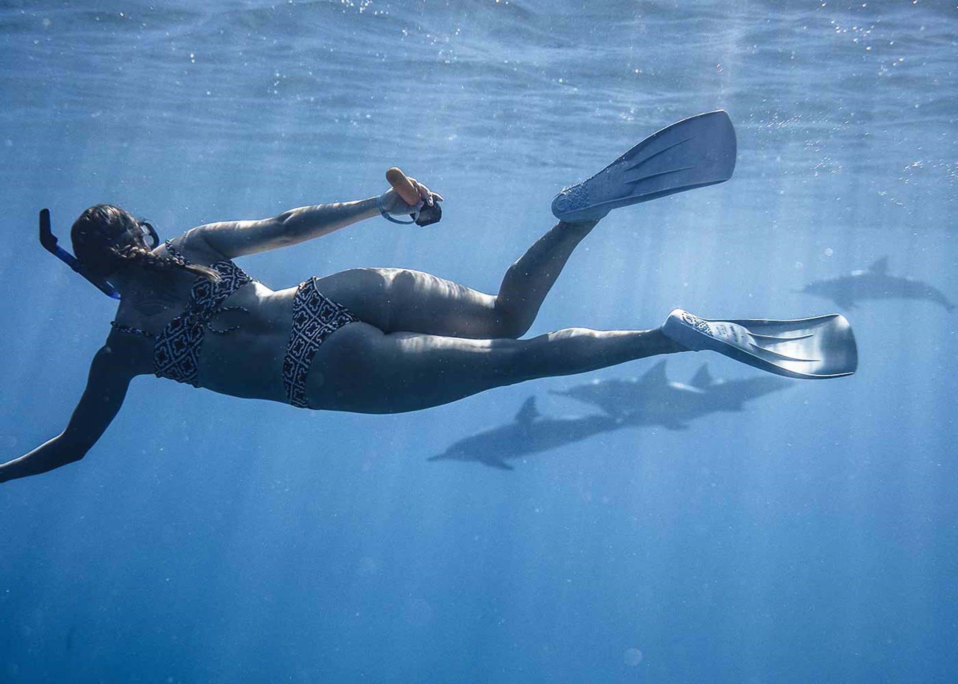 A person swimming underwater with fins and a snorkel.