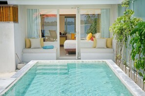 A pool area with a glass door leading to a room with a bed and a chair. - OBLU NATURE Helengeli - All-Inclusive with Free Transfers (Helengeli)