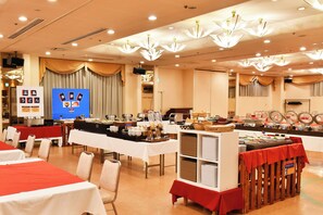 A buffet setup with tables and chairs, a display board with food items, and a ceiling with multiple light fixtures. - Yataro & Yataro Minamikan (Nagasaki)