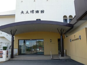 The entrance to a building with a covered entrance and a sign above the door. - Yataro & Yataro Minamikan (Nagasaki)