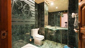 Une salle de bain moderne avec un lavabo en verre, des toilettes et une douche.