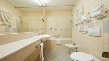 Ein Badezimmer mit Waschbecken, Spiegel, Handtuchhalter, Toilette und Badewanne.
