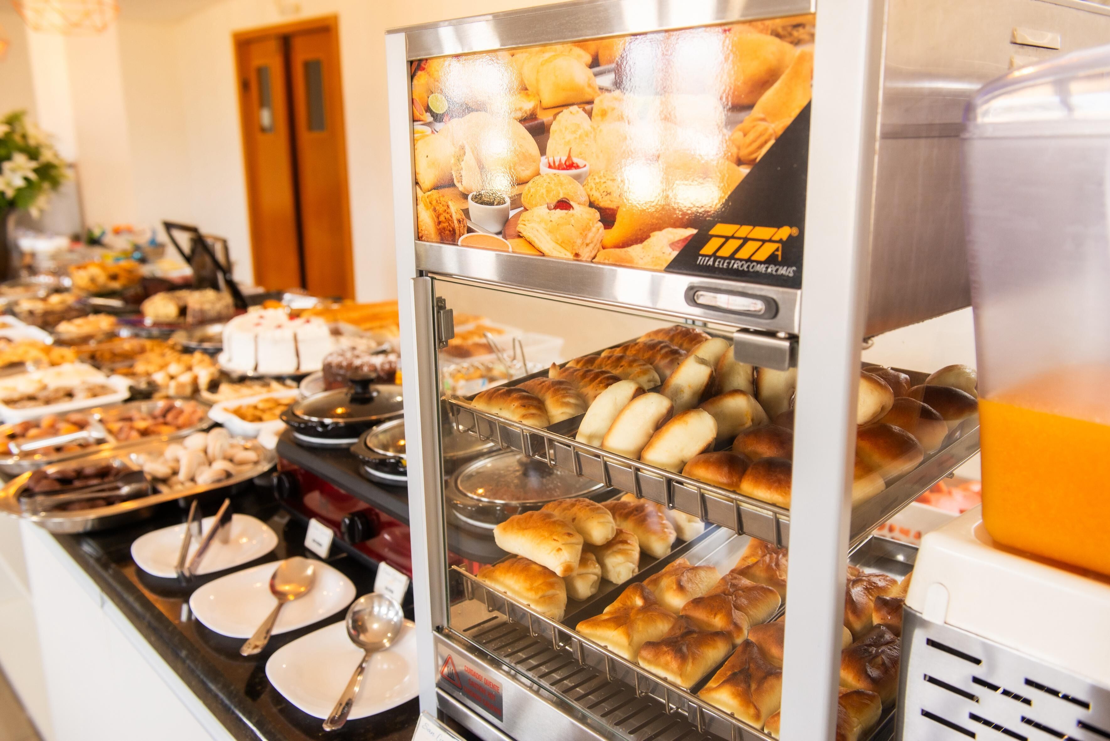 A buffet with various food items and a beverage dispenser.