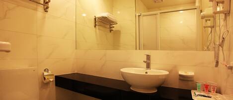 A bathroom with a toilet, sink, and shower.