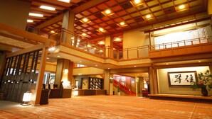A spacious lobby with a high ceiling, wooden beams, and a red staircase. - Kasuien Minami (Matsue)
