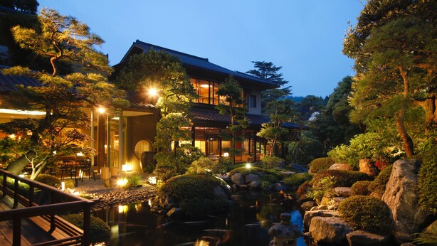 A traditional Japanese-style building with a koi pond, wooden bridge, and well-maintained gardens. - Kasuien Minami (Matsue)