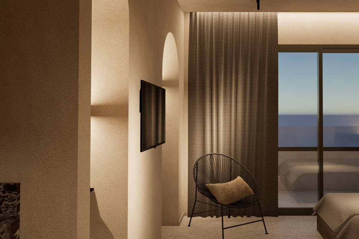 Une chambre à coucher avec un lit, une chaise, une grande fenêtre et un téléviseur fixé au mur.