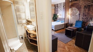 A modern bathroom with a shower, toilet, and sink. The room features a wooden vanity and a mirror. - Studio Orient (Belgrade)