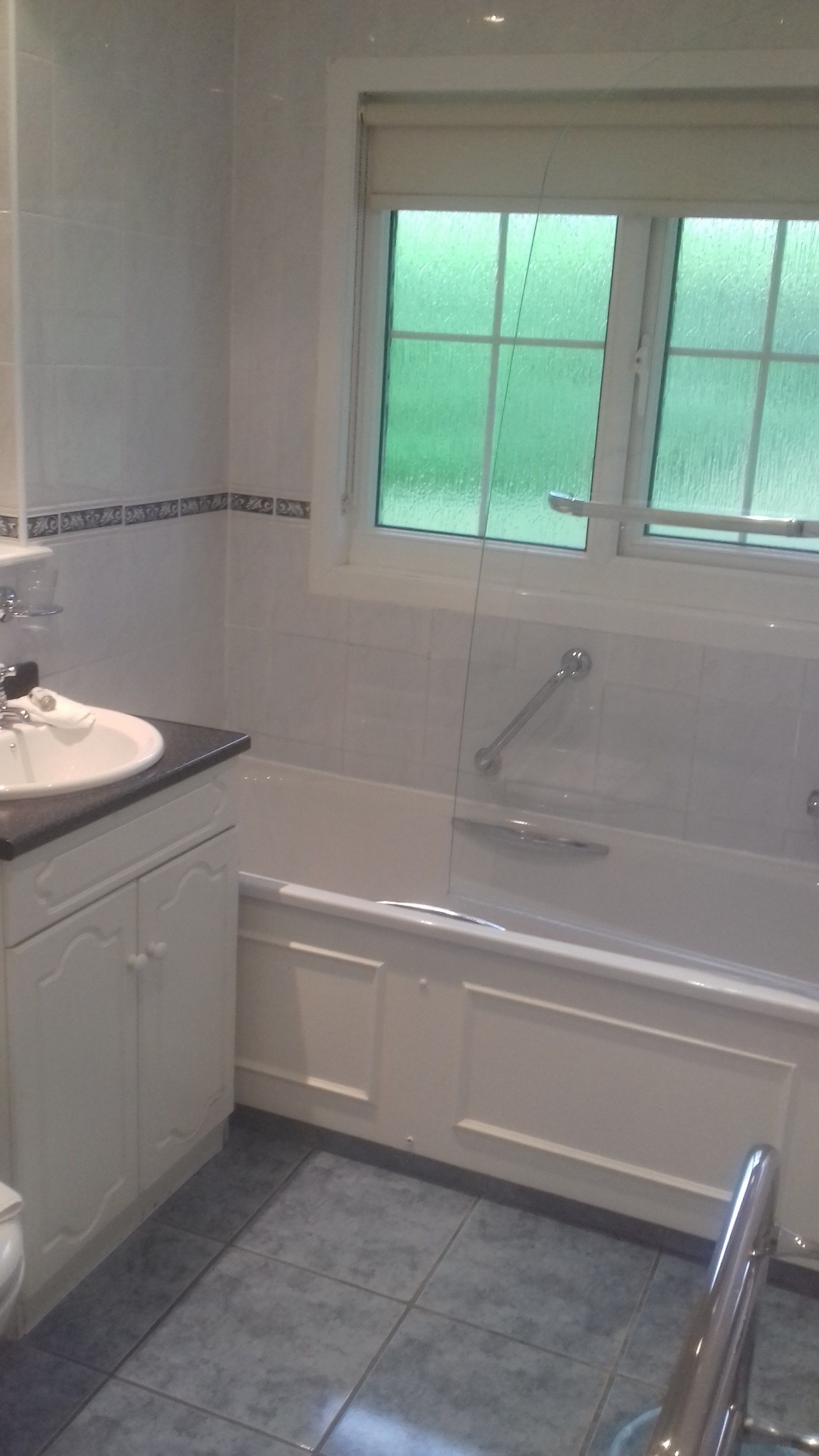 Une salle de bain avec un lavabo blanc, une baignoire et une douche.