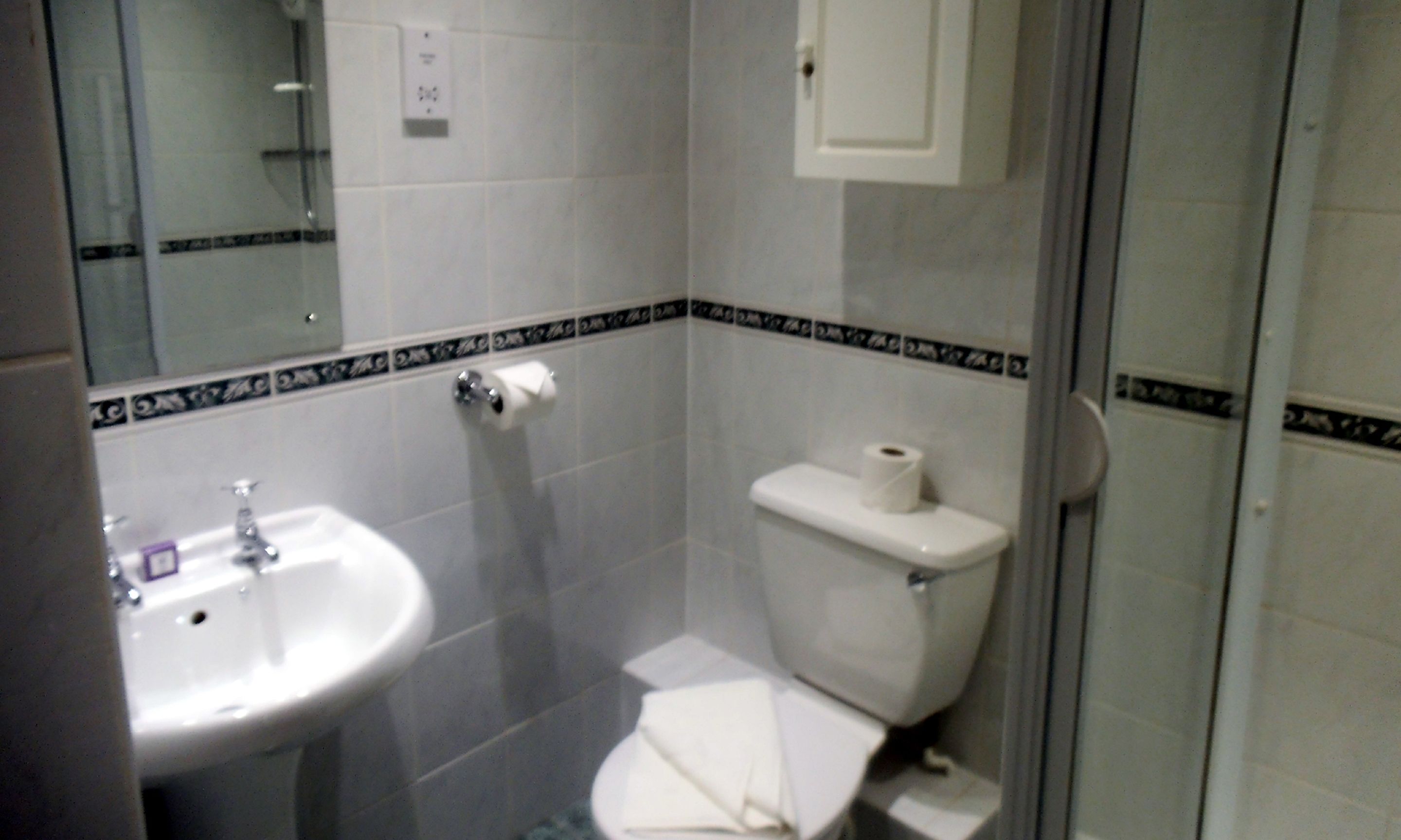 Un baño pequeño con lavamanos, inodoro y espejo.