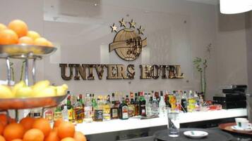 Een bar met verschillende drankflessen en een fruitschaal.