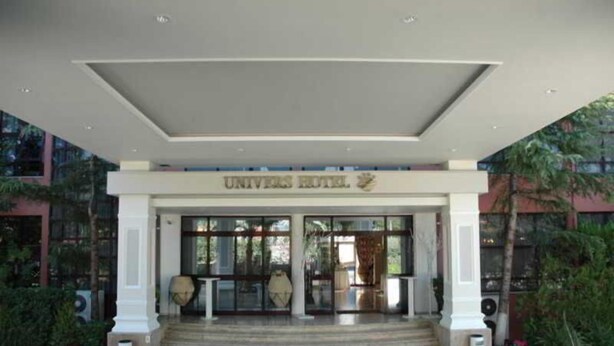 La entrada de un hotel con un porche cubierto, escalones que conducen a él y un letrero sobre las puertas.