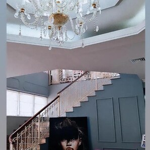 A grand staircase with ornate metal railings and a chandelier. - Univers (Elbasan)