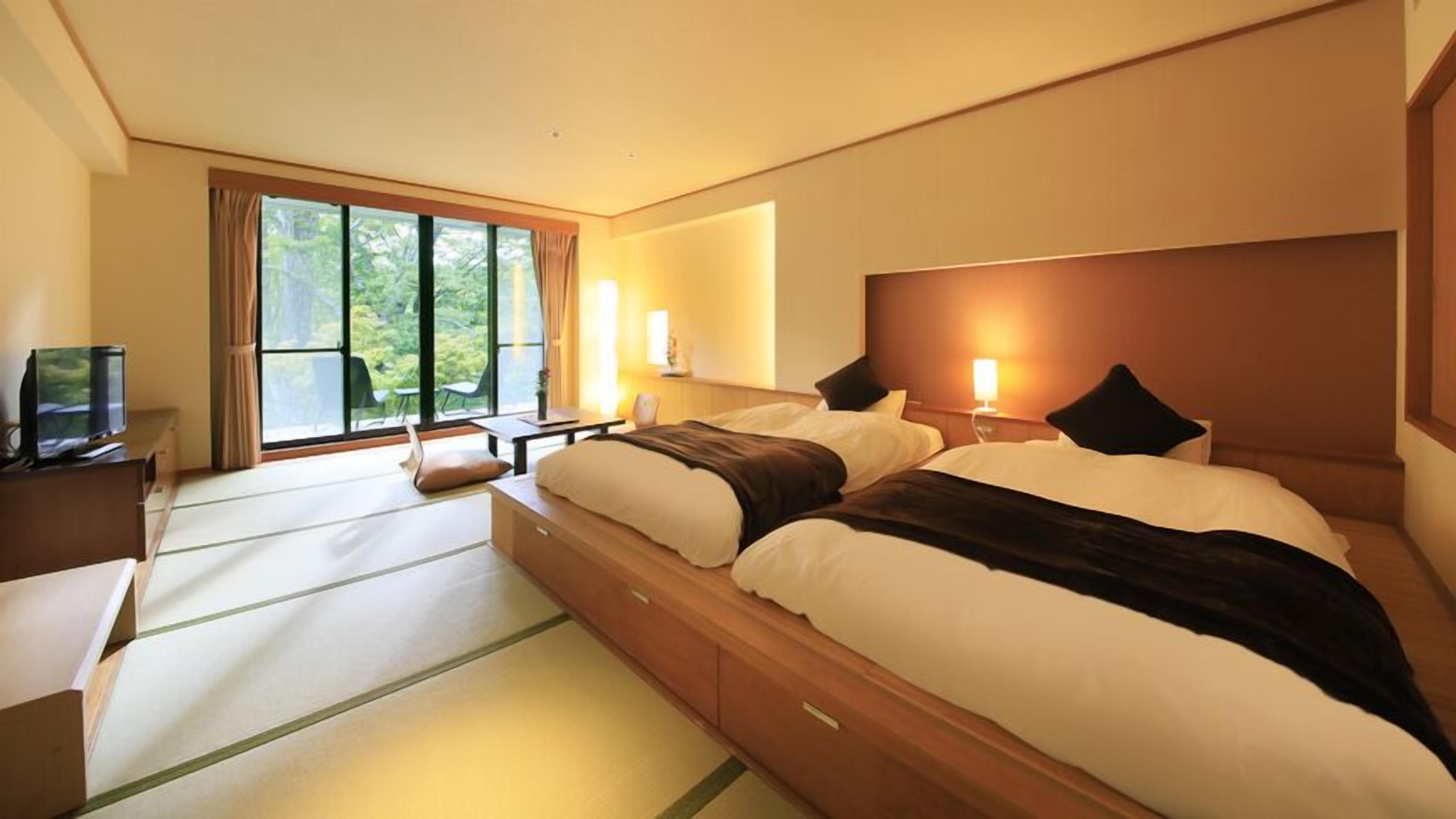 Ein Hotelzimmer mit einem großen Bett, einem Schreibtisch, einem Fernseher und einem Fenster mit Vorhängen.