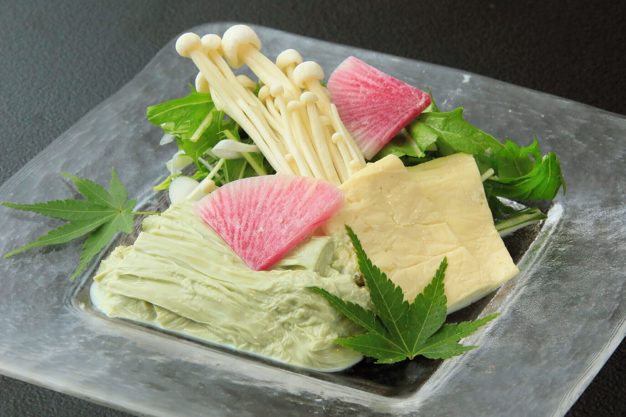 A square plate with a variety of food items including mushrooms, radish, and leafy greens.