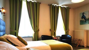 A hotel room with two beds, a desk, chairs, and a radiator. - Hotel La Sapiniere (Remilly-Aillicourt)