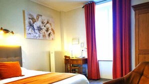 A hotel room with a bed, a desk, a chair, and a window with curtains. - Hotel La Sapiniere (Remilly-Aillicourt)
