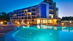 A modern hotel with a swimming pool, multiple balconies, and outdoor seating areas. - South Pearl Apart Complex (Sozopol)