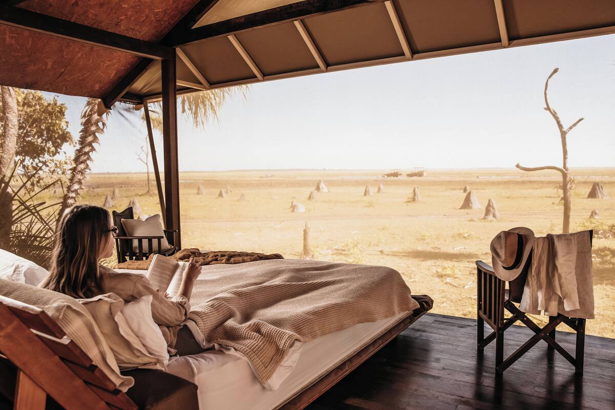 A bed with a view of a desert landscape.