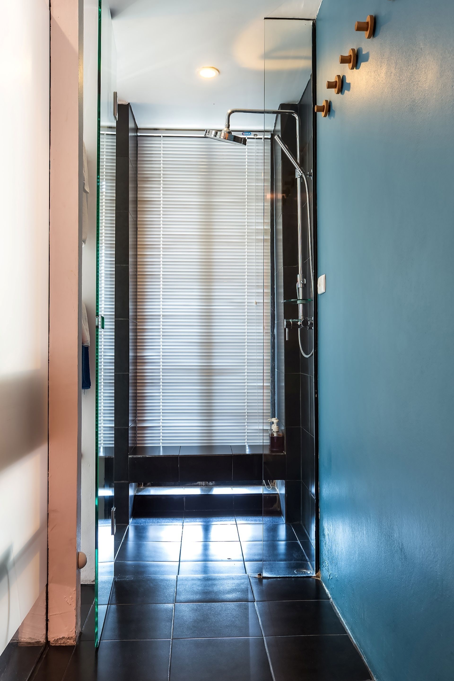 A modern bathroom with a glass shower enclosure, a towel rack, and a visible toilet.
