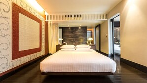 A modern hotel room with a large bed, a stone accent wall, and a decorative wall panel. - LoogChoob Homestay (Bangkok)