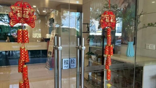 A hotel entrance with glass doors, a reception desk, and a 'Pull' sign. - Jinjiang Inn (Wuxi Liangxi Road Wanda Plaza) (Wuxi)