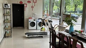 A room with a treadmill, washing machines, and a dining area with a view of the outdoors. - Jinjiang Inn (Wuxi Liangxi Road Wanda Plaza) (Wuxi)