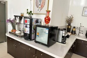 A hotel kitchen counter with a coffee machine, a mini-fridge, and a small refrigerator. - Jinjiang Inn (Wuxi Liangxi Road Wanda Plaza) (Wuxi)
