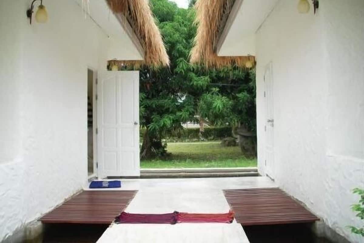 Una habitación con una cama, una puerta y vistas a un jardín.
