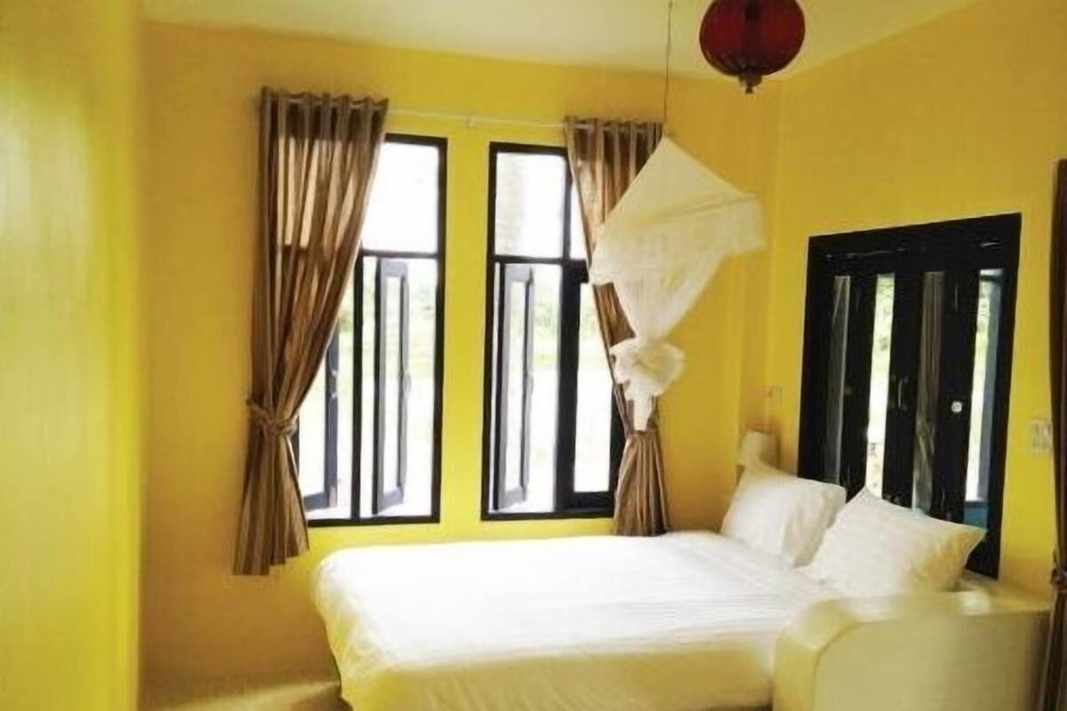 Una habitación con cama, cortinas, ventana y puerta.