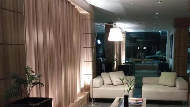 Una sala moderna con sofá, mesa de centro y lámpara.