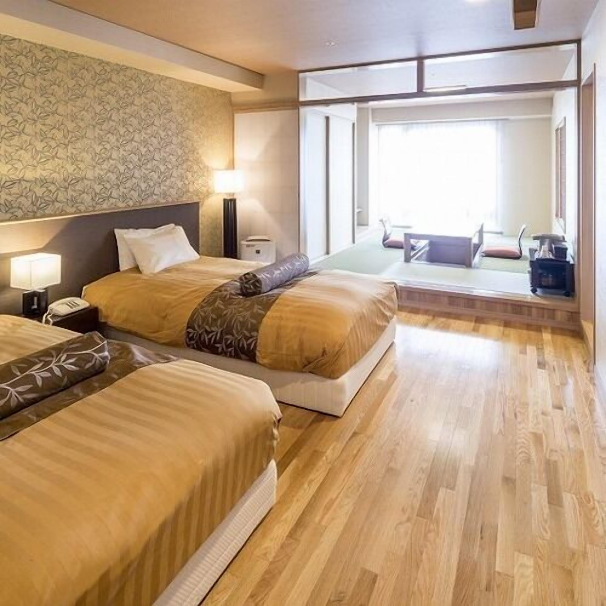 Une chambre d’hôtel avec deux lits, une grande fenêtre et une vue sur l’extérieur.