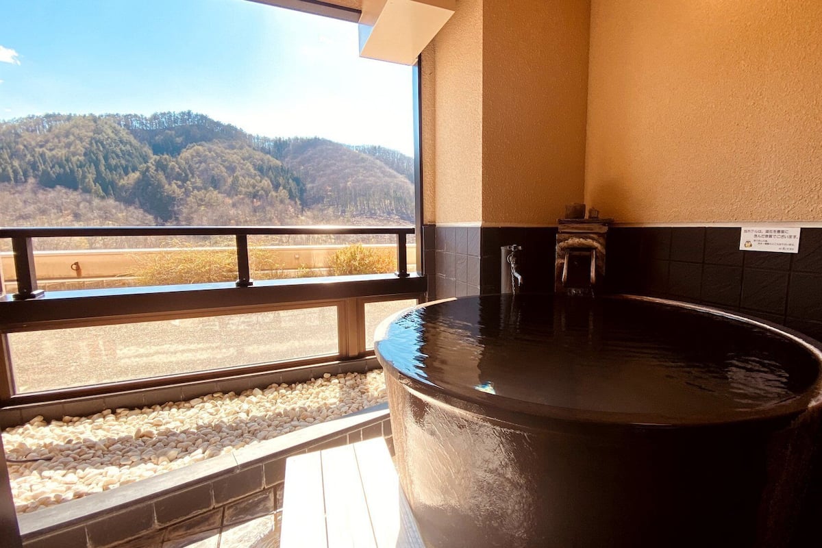 Ein Whirlpool mit Bergblick, ein Fenster mit Aussicht und ein Schild an der Wand.