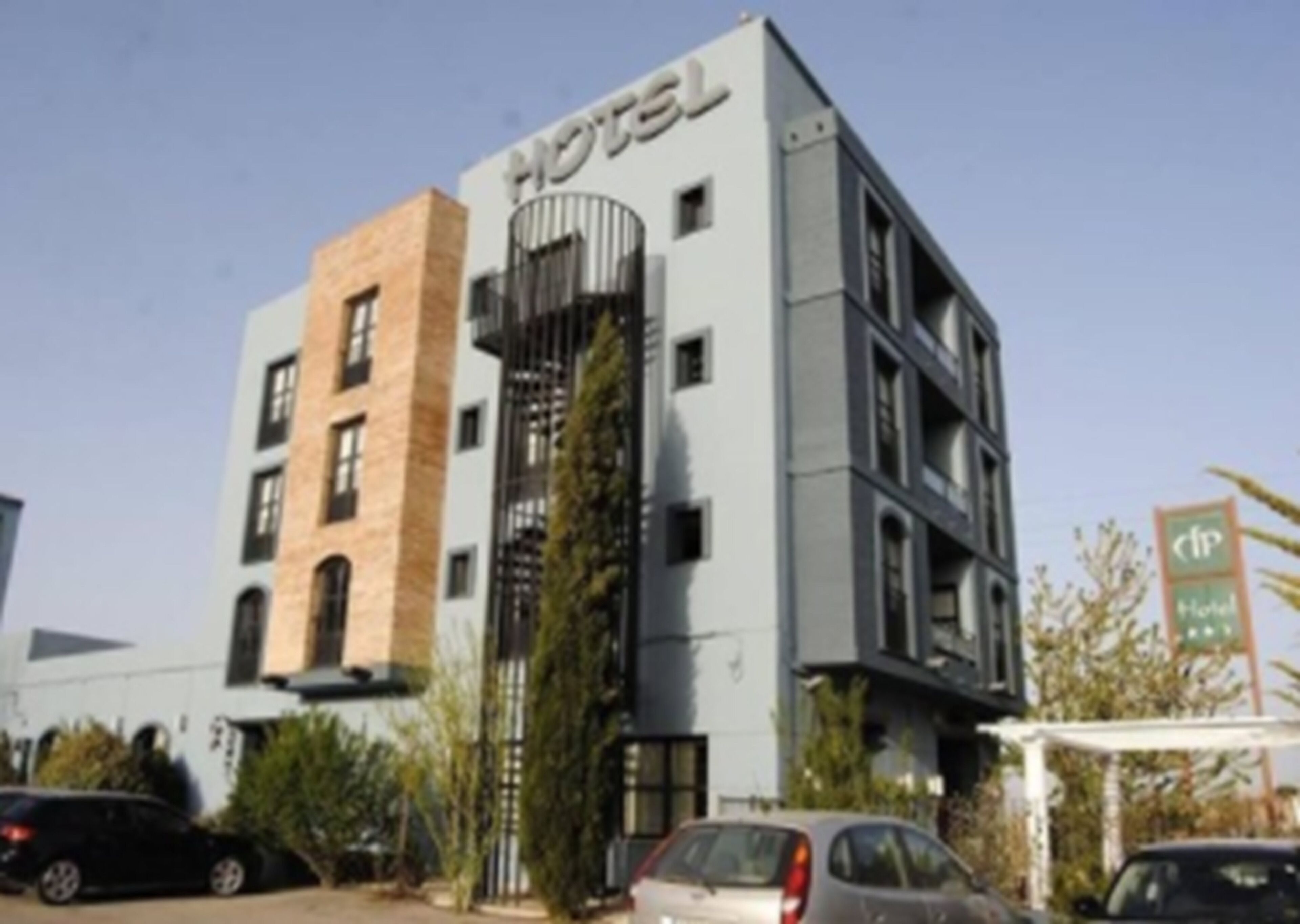 Un edificio de hotel con diseño moderno, que presenta un letrero destacado que dice 'HOTEL' en la parte superior.