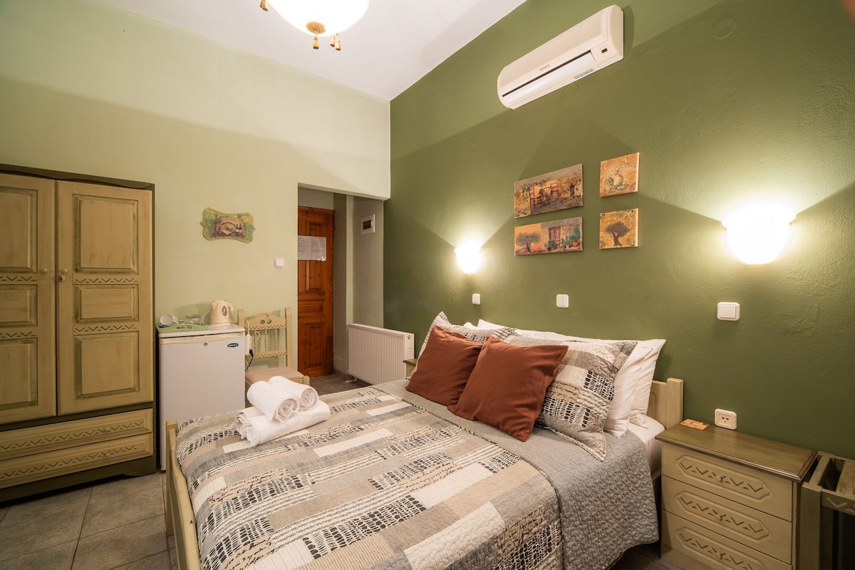 Een slaapkamer met een bed, nachtkastje en een kledingkast.