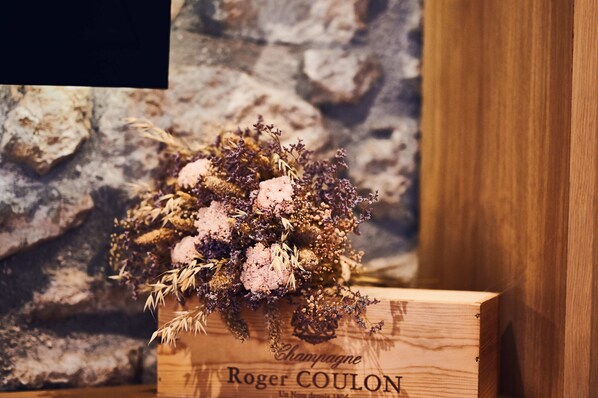 A wooden box with a bouquet of dried flowers and greenery, labeled "Champagne Roger COULON."