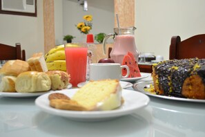 A breakfast table with various food items and drinks.