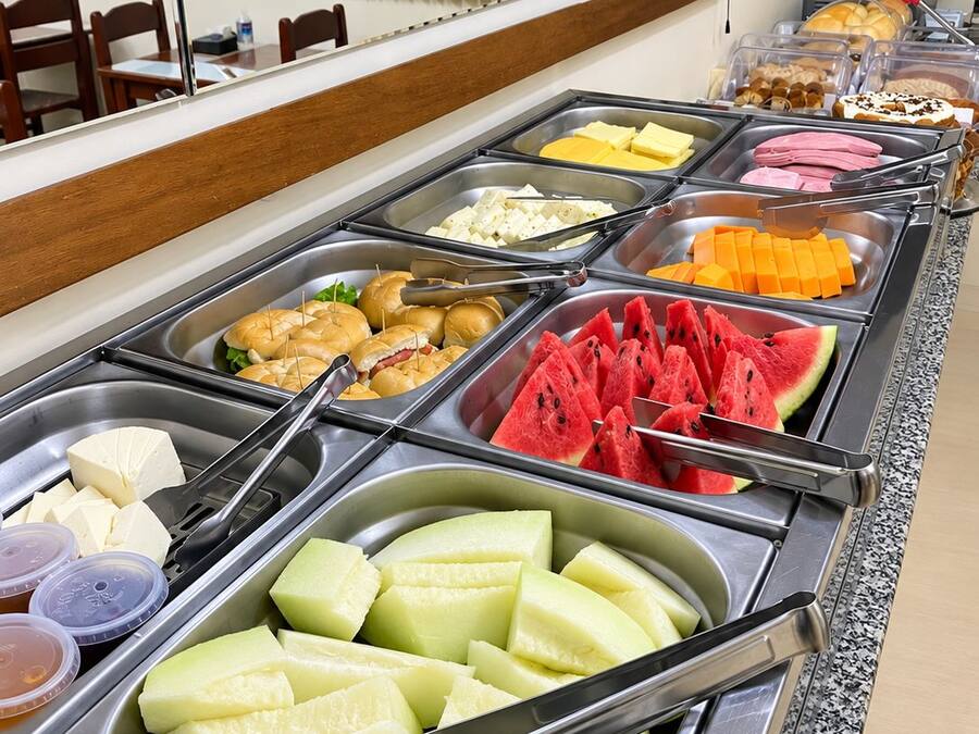 A buffet with various food options including fruits, cheeses, and meats.