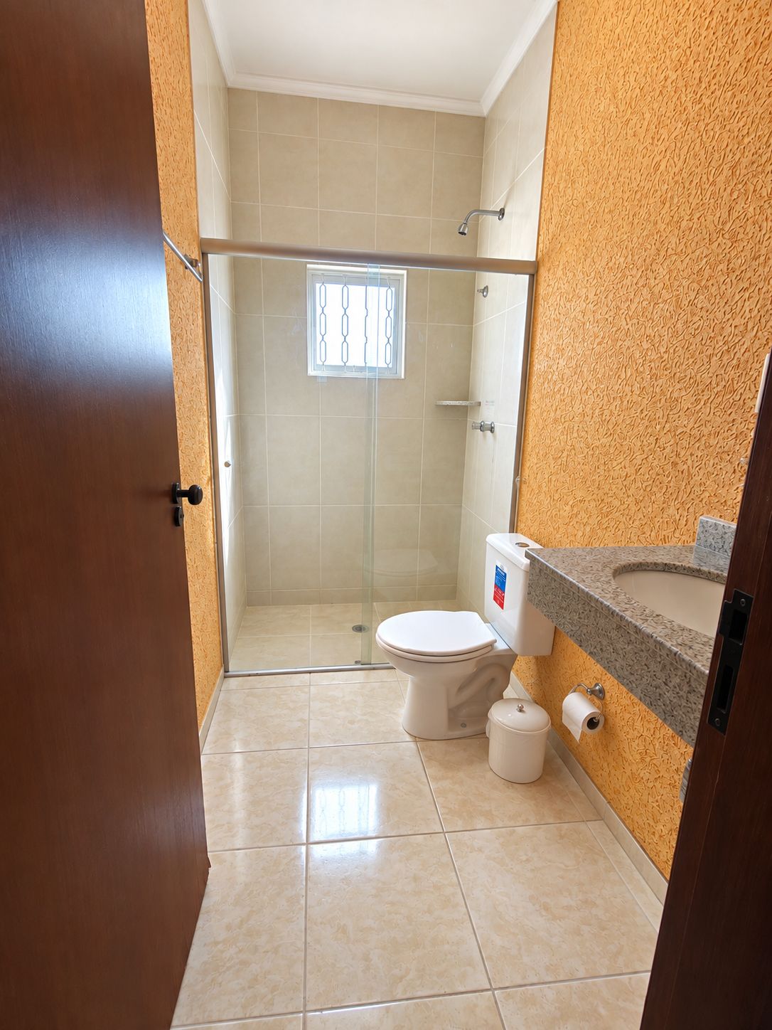 Ein Badezimmer mit Dusche, Toilette und Waschbecken.