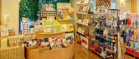 A retail store with a wooden counter, shelves stocked with various products, and a display area with hanging items.