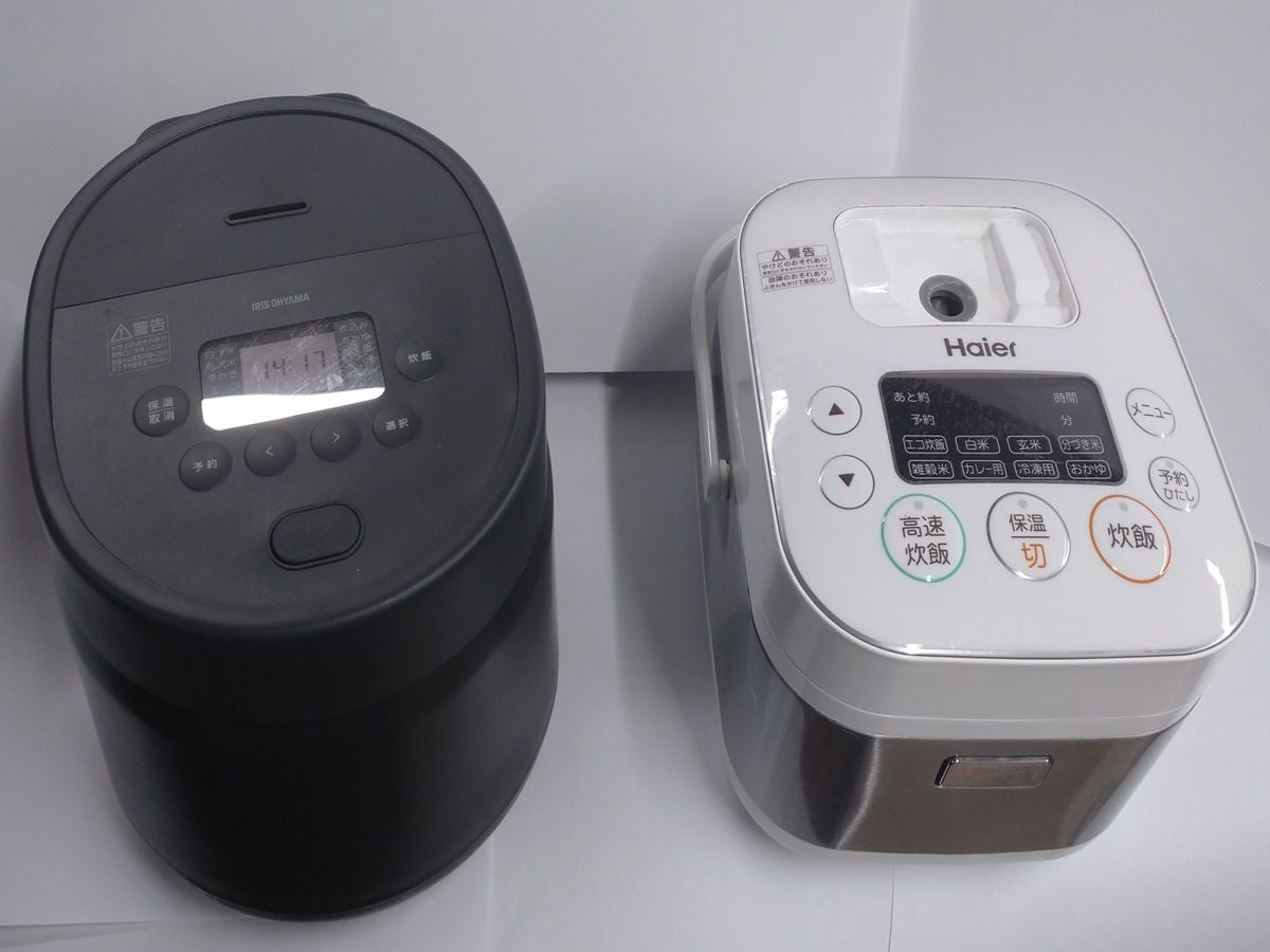 Two kitchen appliances, a rice cooker and a coffee maker, placed on a white surface.