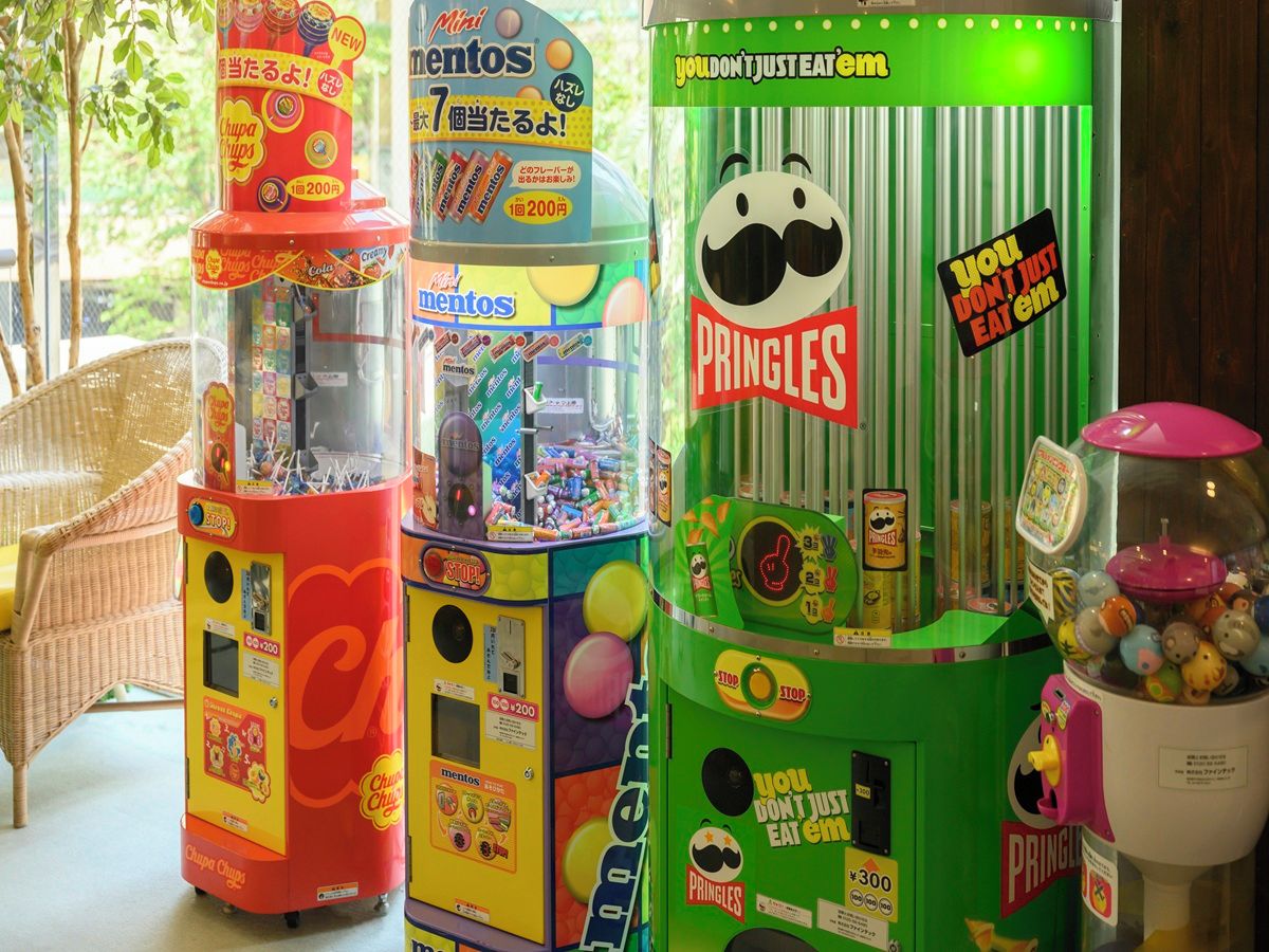 A row of vending machines with snacks, including Pringles and mints.