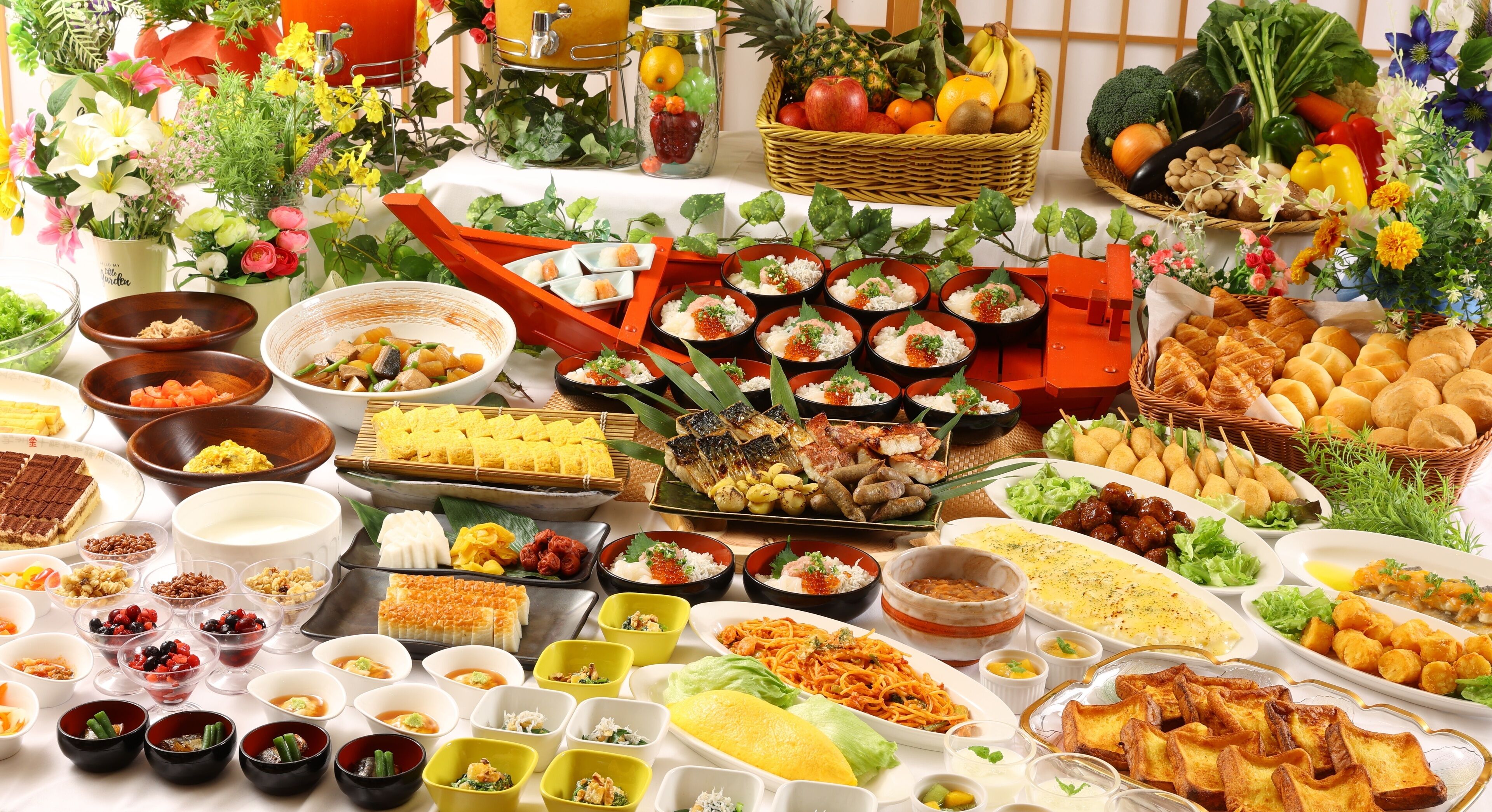 A table with various dishes, fruits, and flowers.