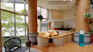 Una hall con reception, area salotto e ampie finestre.