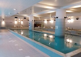 An indoor swimming pool with tiled walls and a tiled floor.